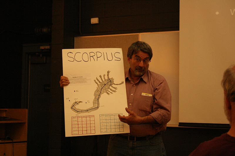 Al Washburn shows a student's poster on the constellation Scorpius.