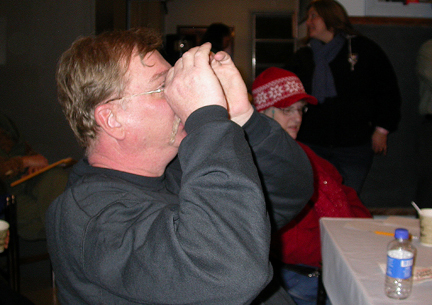 Photo by Ray Kaville
Winter Solstice party 12/13/08 - Jim Podpulucha checks out a photo as part of the yearly quiz.
