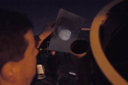 Photo by Alan Chaniewski
With the moon being almost full Greg Barker had to tone down his scope to 8", and still had enought light being projected through his eyepiece to be projected on to a white sheet of paper several inches away. 
